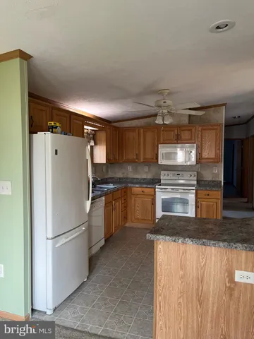 a kitchen with granite countertop a refrigerator and a sink