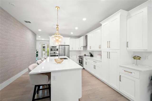 a kitchen with white cabinets sink and stove
