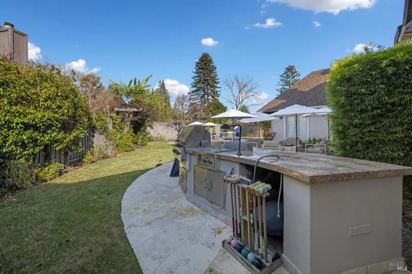 a patio with a table and chairs under an umbrella