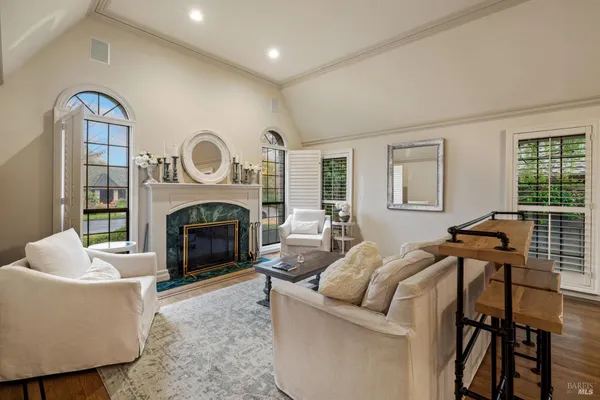 a bedroom with a large bed a flat tv screen and large window