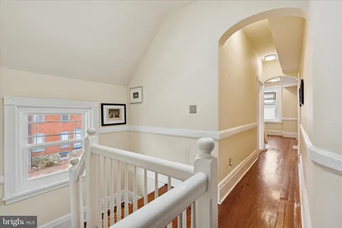 a view of a hallway with wooden floor and entryway