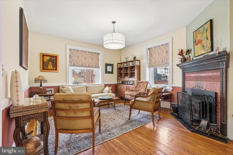 a living room with fireplace furniture and a wooden floor