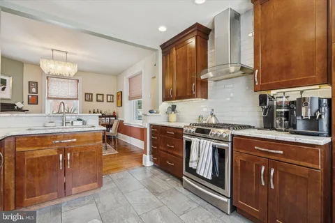 a kitchen with stainless steel appliances granite countertop a stove top oven a sink dishwasher and a refrigerator