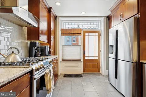 a kitchen with stainless steel appliances granite countertop a refrigerator and a sink