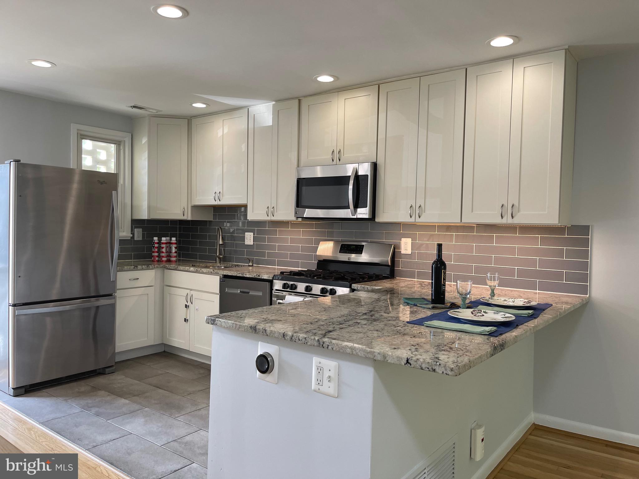 108 G Street Southwest, Unit 105 Washington, DC 20024 - Photo 1 of 52 a kitchen with granite countertop a refrigerator a sink and white cabinets