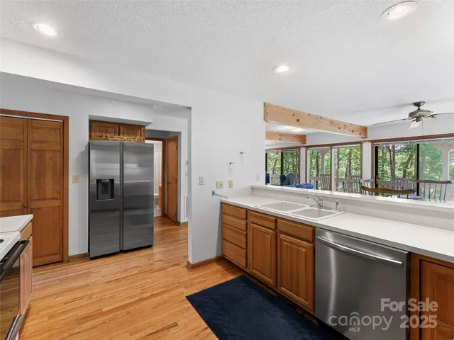 a large kitchen with stainless steel appliances granite countertop a refrigerator and a sink