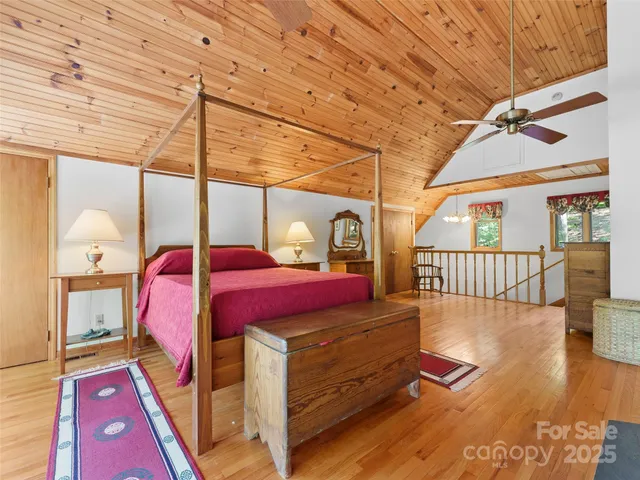 a view of a bedroom with a bed and wooden floor