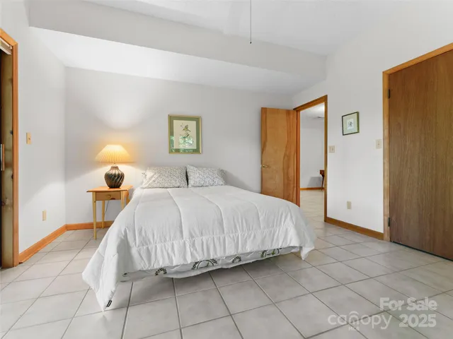 a bedroom with a bed and a potted plant