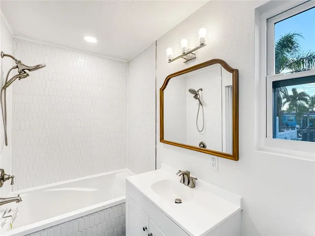 a bathroom with a sink a bathtub and a mirror