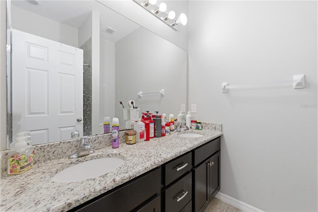 4810 Poolside Drive St. Cloud, FL 34769 - Photo 12 of 26 a bathroom with a sink vanity and a mirror