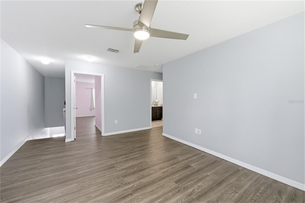 4810 Poolside Drive St. Cloud, FL 34769 - Photo 15 of 26 an empty room with wooden floor and ceiling fan