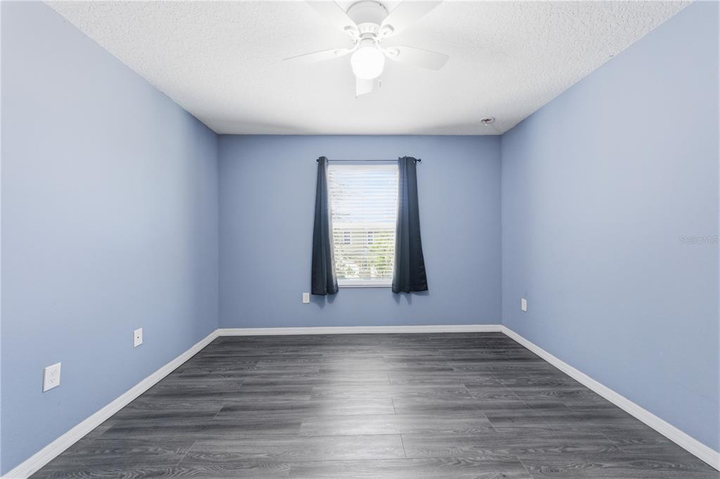4810 Poolside Drive St. Cloud, FL 34769 - Photo 19 of 26 a view of an empty room with wooden floor and a window