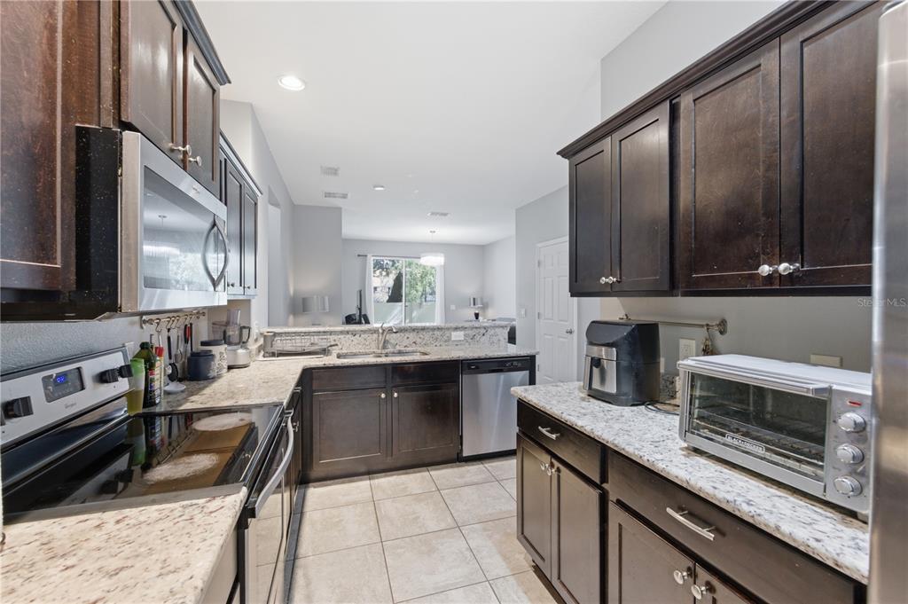4810 Poolside Drive St. Cloud, FL 34769 - Photo 7 of 26 a kitchen with a sink stove top oven and cabinets