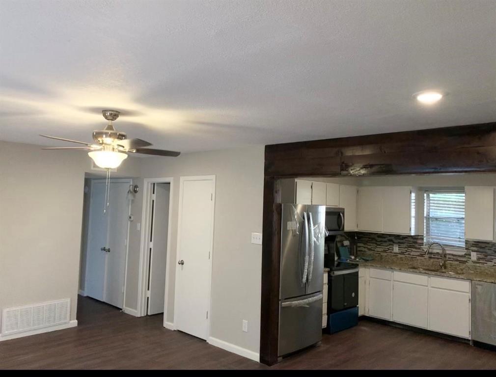 a kitchen with stainless steel appliances granite countertop a refrigerator a sink and dishwasher