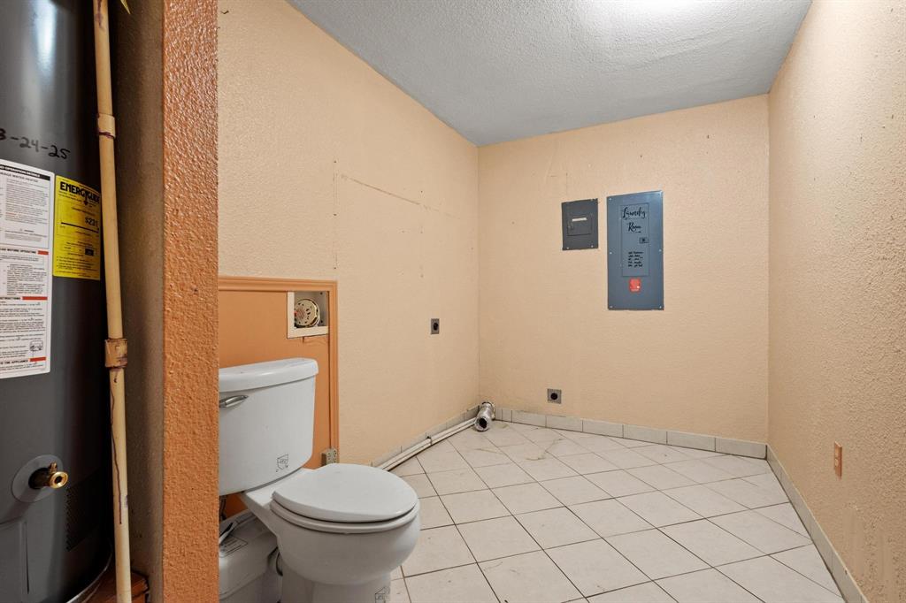 1417 Morrison Drive Denison, TX 75020 - Photo 16 of 30 Bathroom featuring water heater, light tile patterned flooring, a textured ceiling, and a textured wall