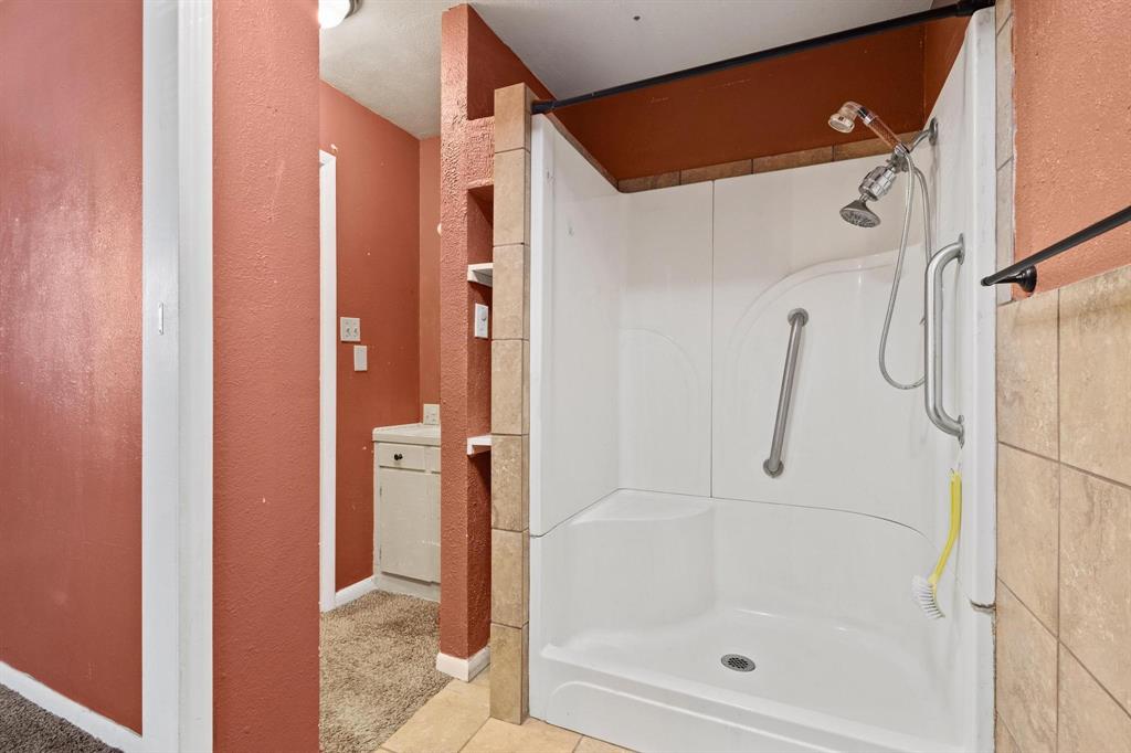 1417 Morrison Drive Denison, TX 75020 - Photo 26 of 30 Bathroom featuring a textured wall, a shower, and tile patterned floors