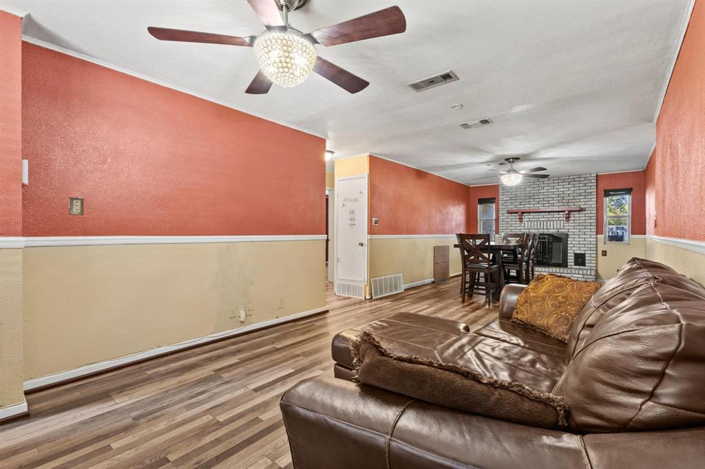 1417 Morrison Drive Denison, TX 75020 - Photo 6 of 30 Living area featuring wood finished floors, a fireplace, ceiling fan, and a textured wall