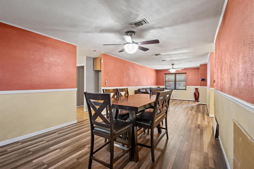 1417 Morrison Drive Denison, TX 75020 - Photo 9 of 30 Dining space featuring a textured wall, wood finished floors, a textured ceiling, and crown molding
