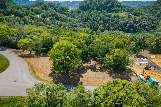 an aerial view of residential house with outdoor space and trees all around