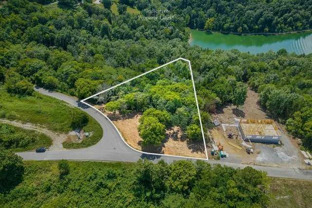 an aerial view of residential house with outdoor space and trees all around