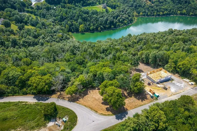 an aerial view of residential house with outdoor space and trees all around