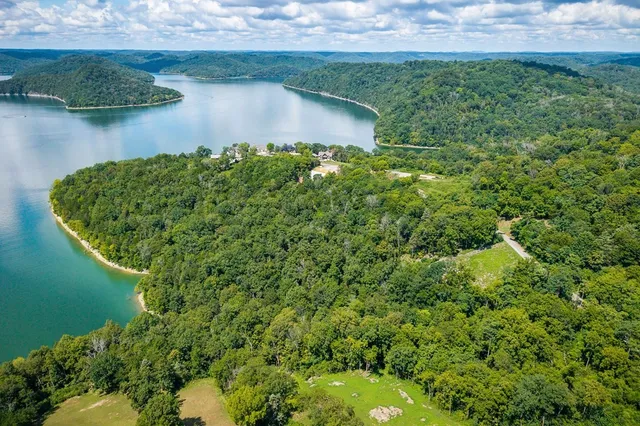 an aerial view of a house with a yard and lake view
