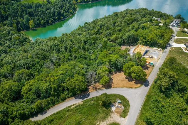 an aerial view of a house with a yard and lake view