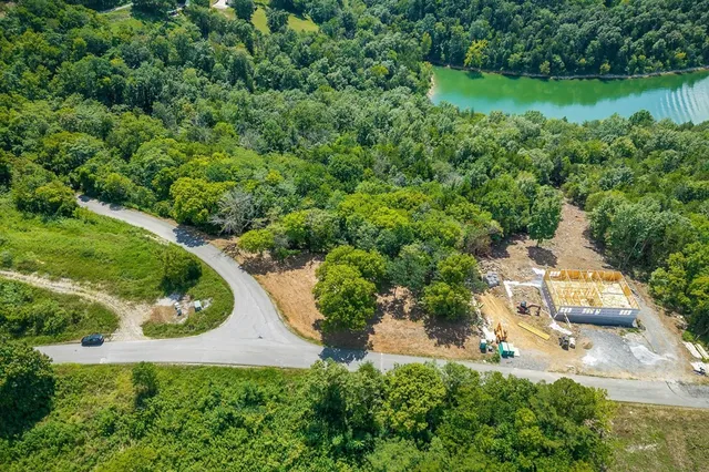 an aerial view of residential house with outdoor space and trees all around
