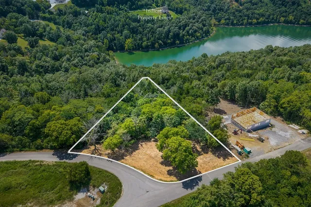 an aerial view of a house with a yard and lake view