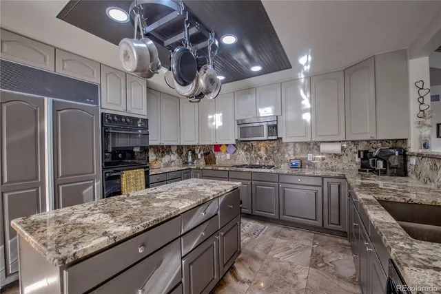 a kitchen with stainless steel appliances granite countertop a sink a stove and a refrigerator