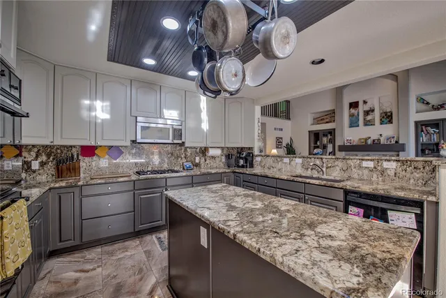 a kitchen with kitchen island granite countertop a sink and stove
