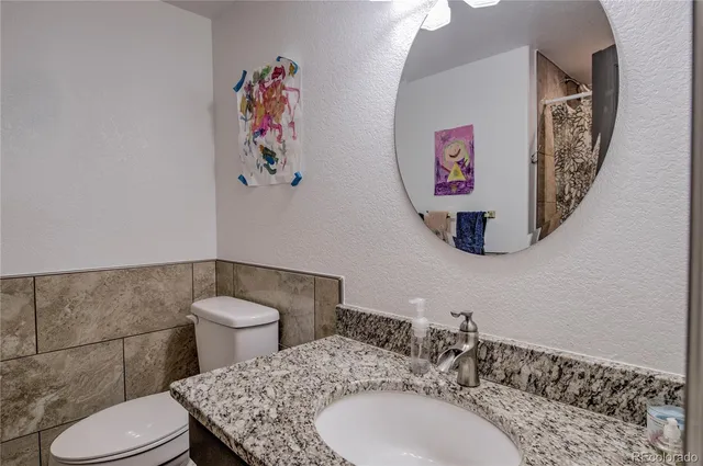 a bathroom with a toilet a sink and mirror