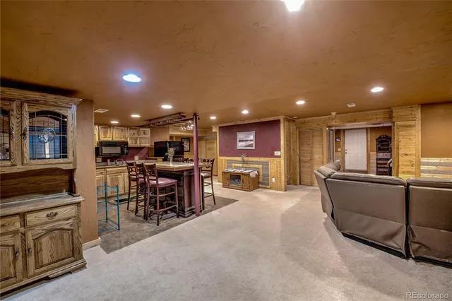 a living room with furniture a table and kitchen view