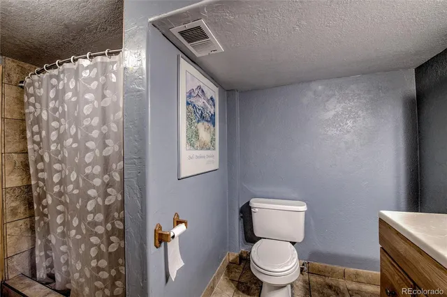 a bathroom with a toilet and a shower curtain