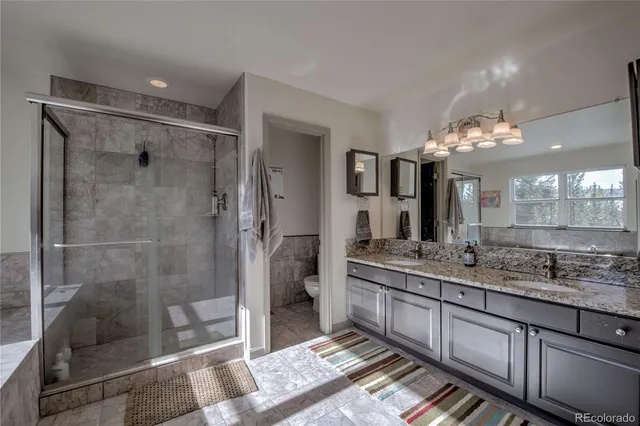 a bathroom with a granite countertop sink a mirror and a shower