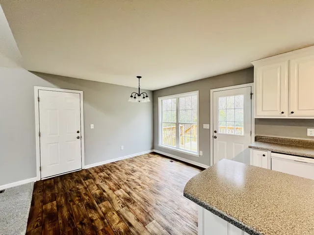 a view of a kitchen with wooden floor and a sink
