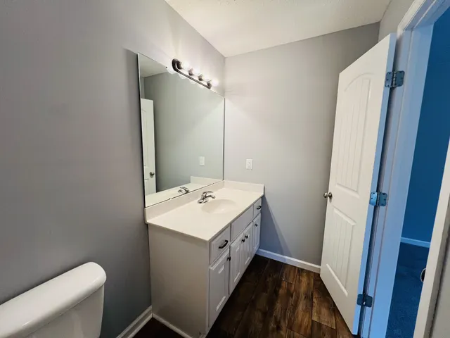 a bathroom with a double vanity sink toilet and mirror