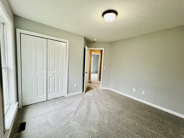 an empty room with windows and closet