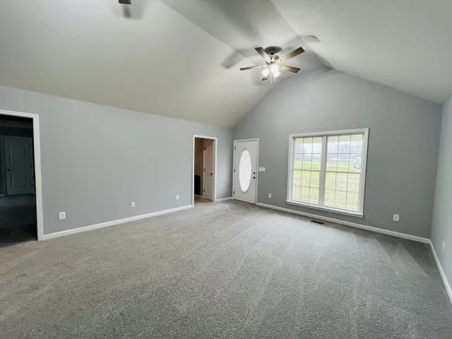 a view of an empty room with a chandelier fan