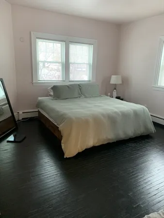 a bedroom with a bed and wooden floor