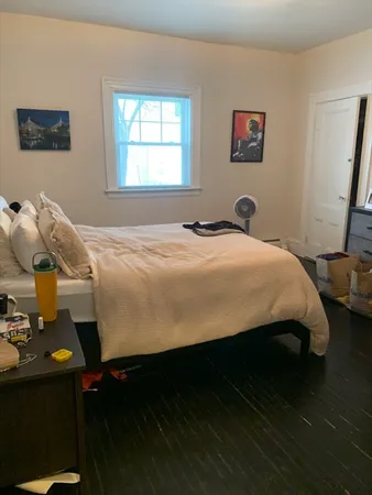 a bed sitting in a bedroom next to a window