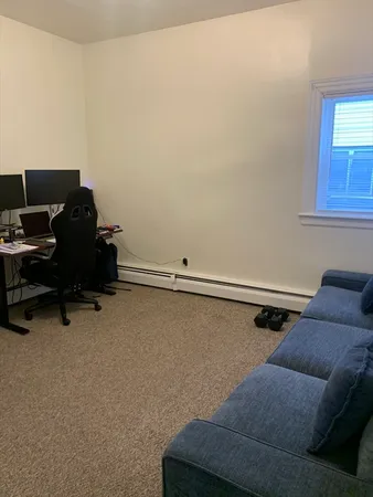 a living room with furniture and a air conditioner vent