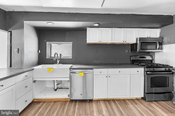 a kitchen with stainless steel appliances a stove microwave and cabinets