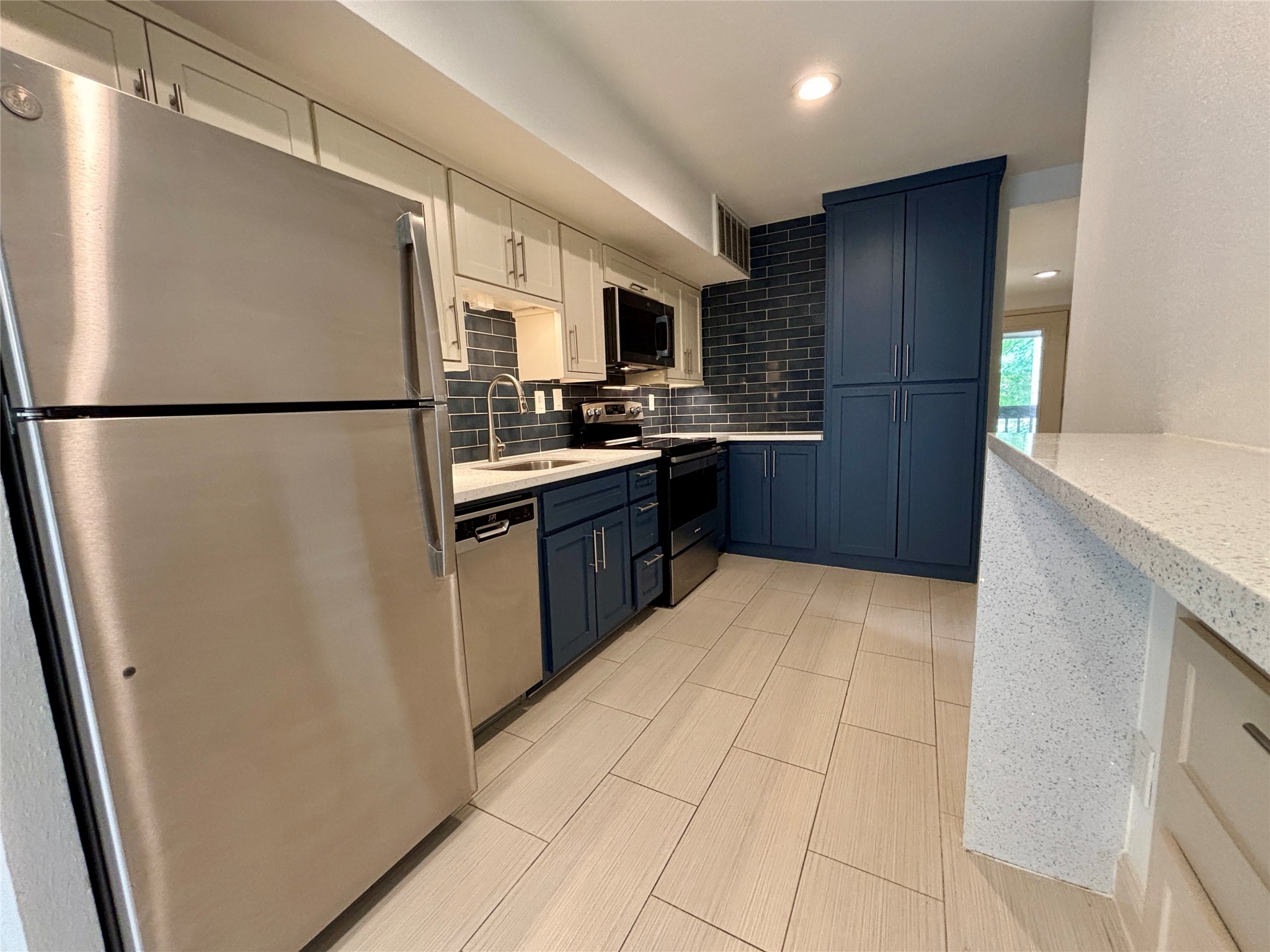 12900 Walden Road, Unit 508E Montgomery, TX 77356 - Photo 6 of 25 a kitchen with stainless steel appliances a refrigerator sink and microwave