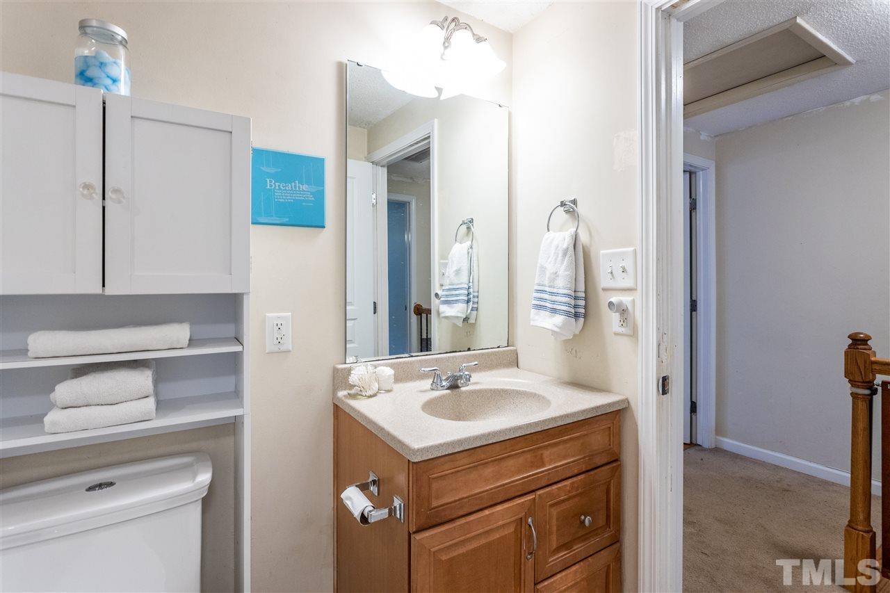 7720 Sandra Lane Raleigh, NC 27615 - Photo 11 of 25 a bathroom with a sink vanity granite and a mirror
