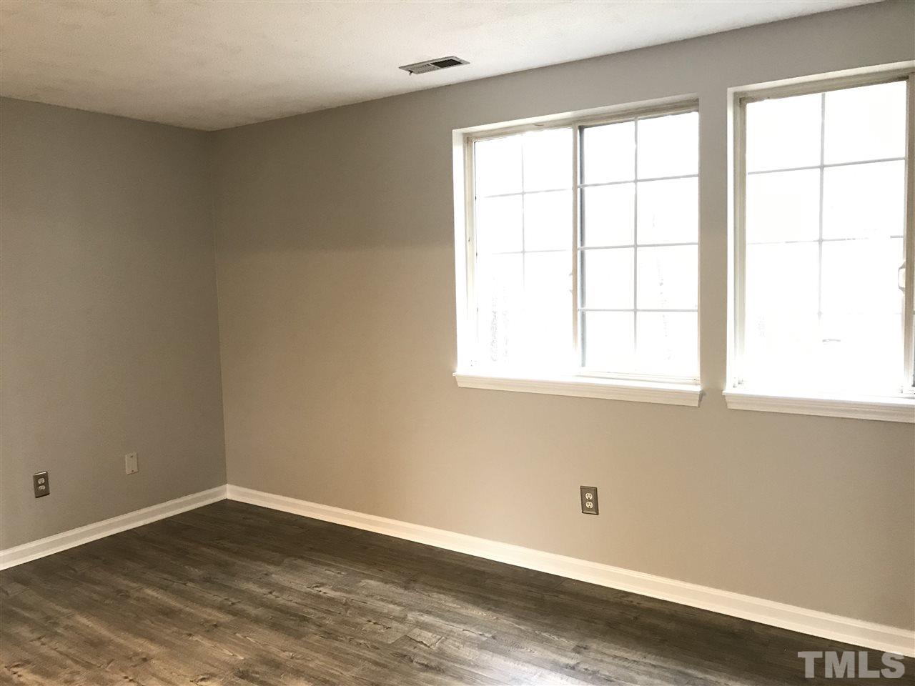 7720 Sandra Lane Raleigh, NC 27615 - Photo 18 of 25 an empty room with wooden floor and windows