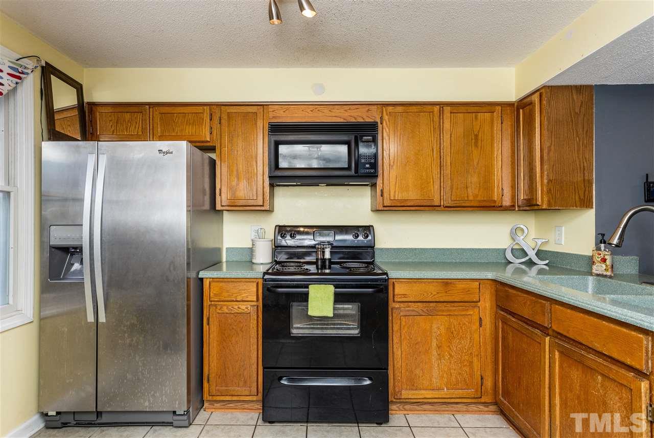 7720 Sandra Lane Raleigh, NC 27615 - Photo 5 of 25 a kitchen with stainless steel appliances granite countertop a refrigerator and a stove