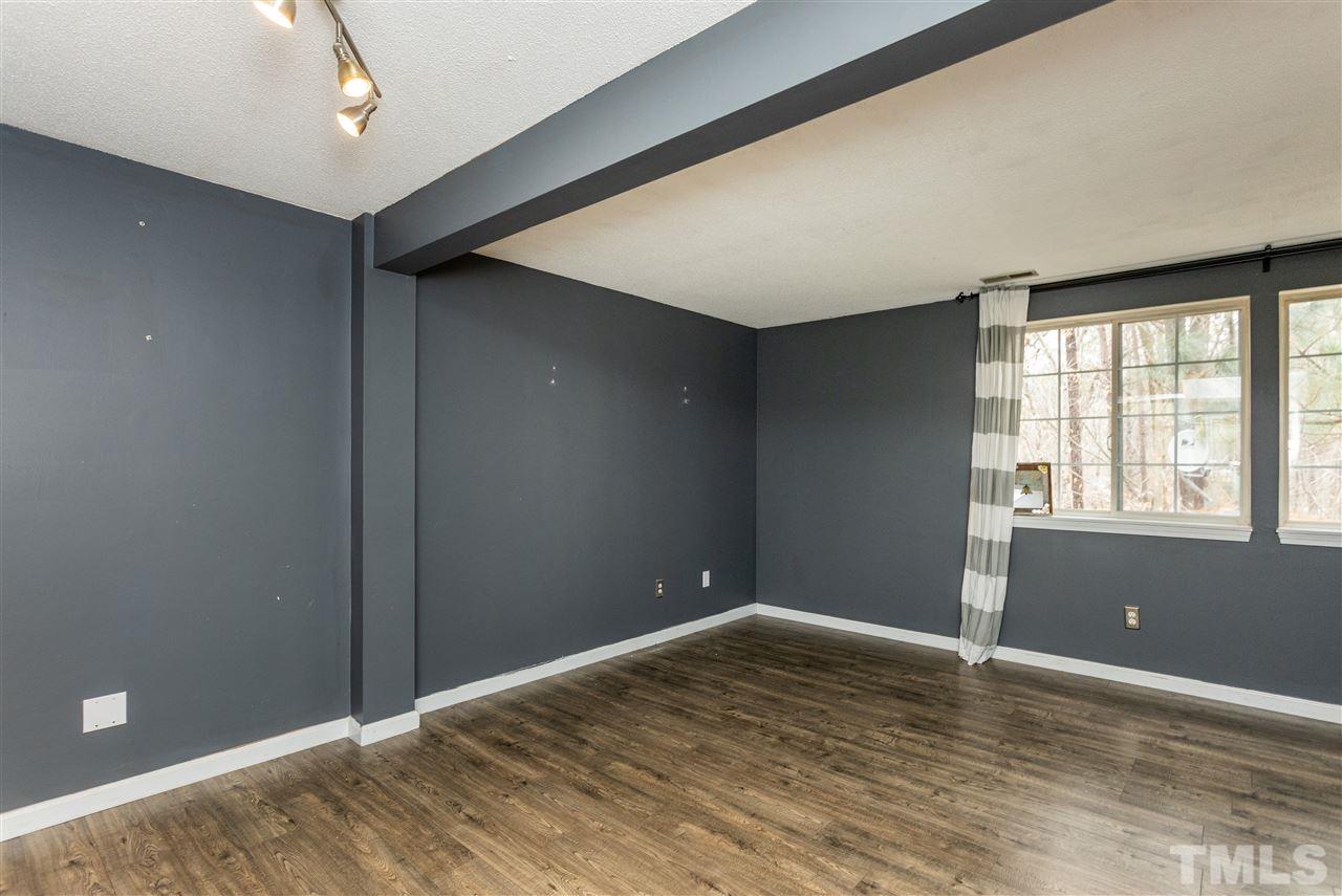 7720 Sandra Lane Raleigh, NC 27615 - Photo 10 of 25 a view of an empty room with wooden floor and a window