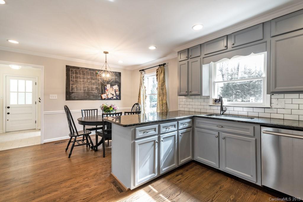 2800 High Ridge Road Charlotte, NC 28270 - Photo 9 of 34 a kitchen with stainless steel appliances granite countertop wooden floor sink table and chairs