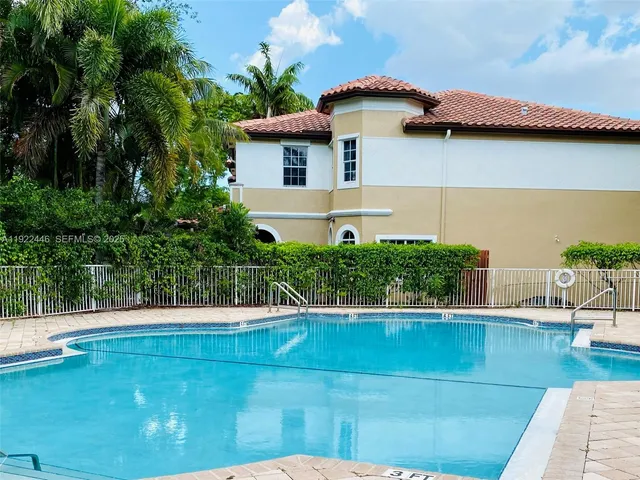 a view of a white house with a yard and sitting area